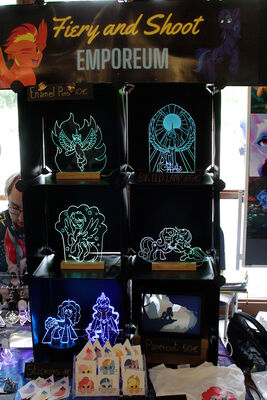 Folr the first time there was a vendor at GalaCon who mainly sold similar items as me. He has laser-cut and -etched vectors, a limited slection of pictures, a nice table set-up with black backgrounds, just one type of base. Nice work. A more professional-looking version of my table. But a smaller selection of characters as well.